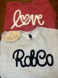 Yarn embroidered crewneck sweatshirts in multiple colors and designs including RobCo, Love, Devils, Nana, and East