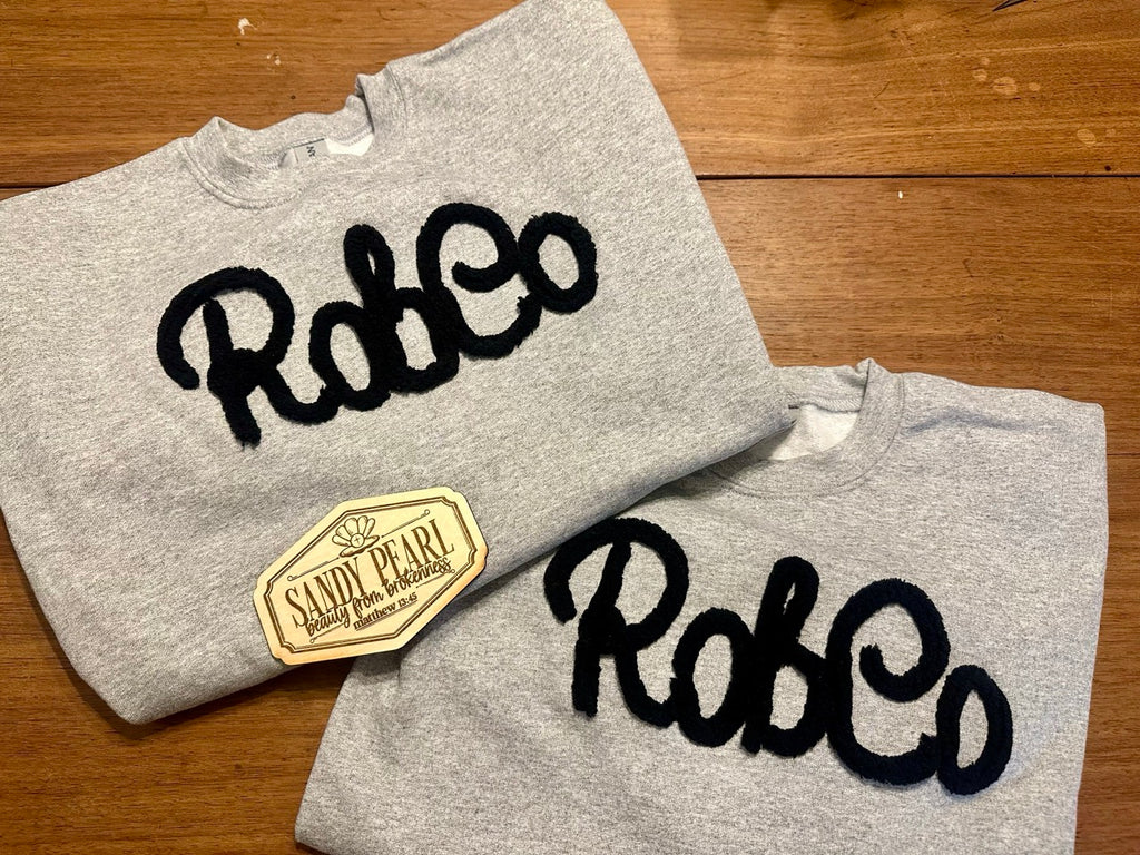 RobCo yarn embroidered crewneck sweatshirts in heather gray with Sandy Pearl branded tag